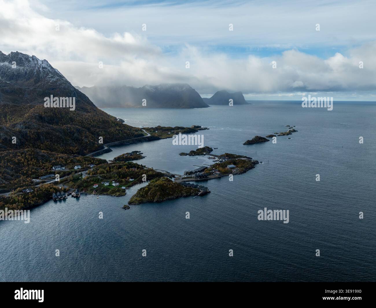 Vue aérienne de Hamn i Senja Resort niché entre les montagnes escarpées et la mer bleu profond sous un ciel nuageux à Skaland, Troms, Norvège. Banque D'Images