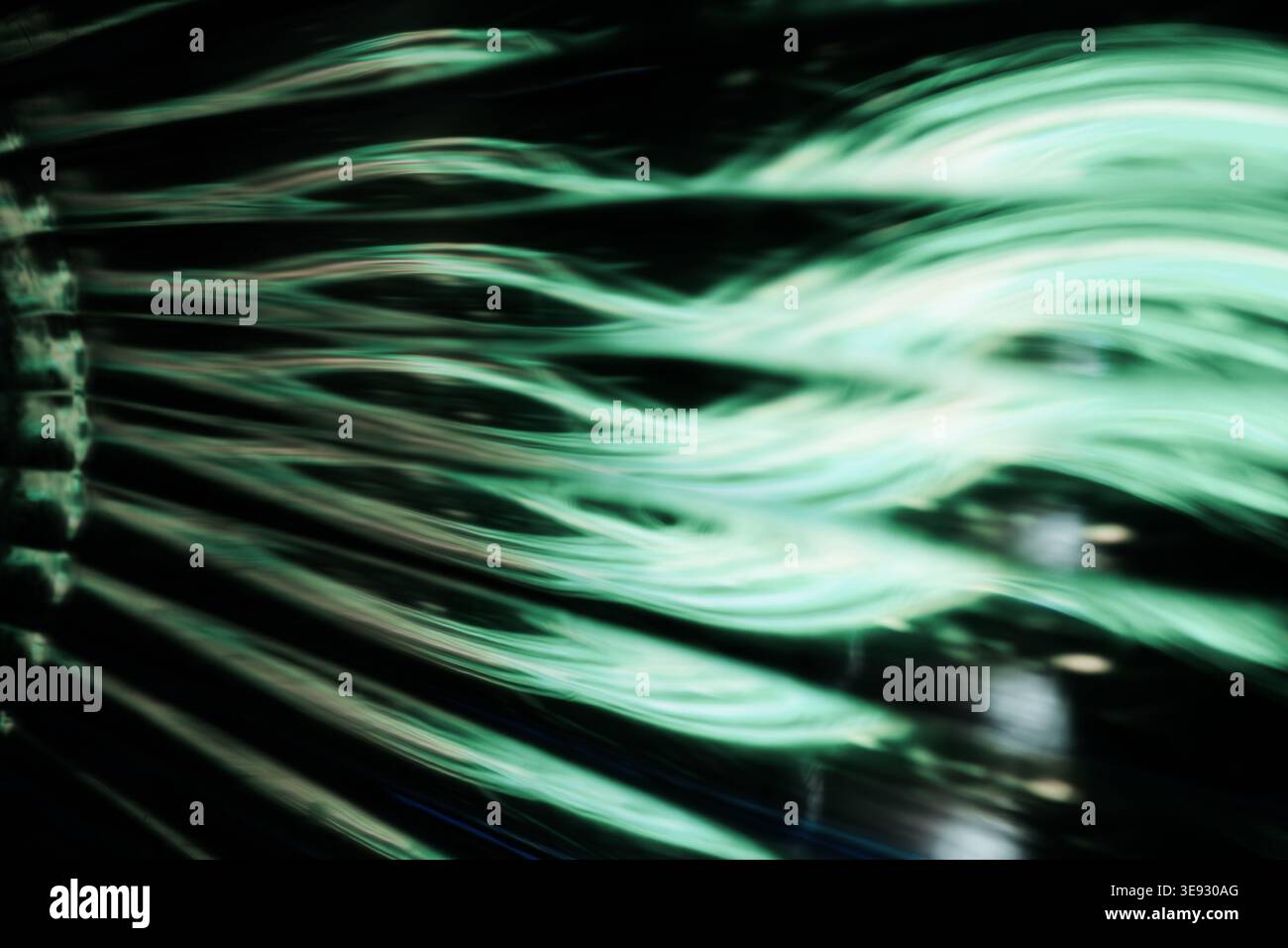 Traînées de lumière ondulée verte éclatante abstraite sur un fond noir foncé Banque D'Images