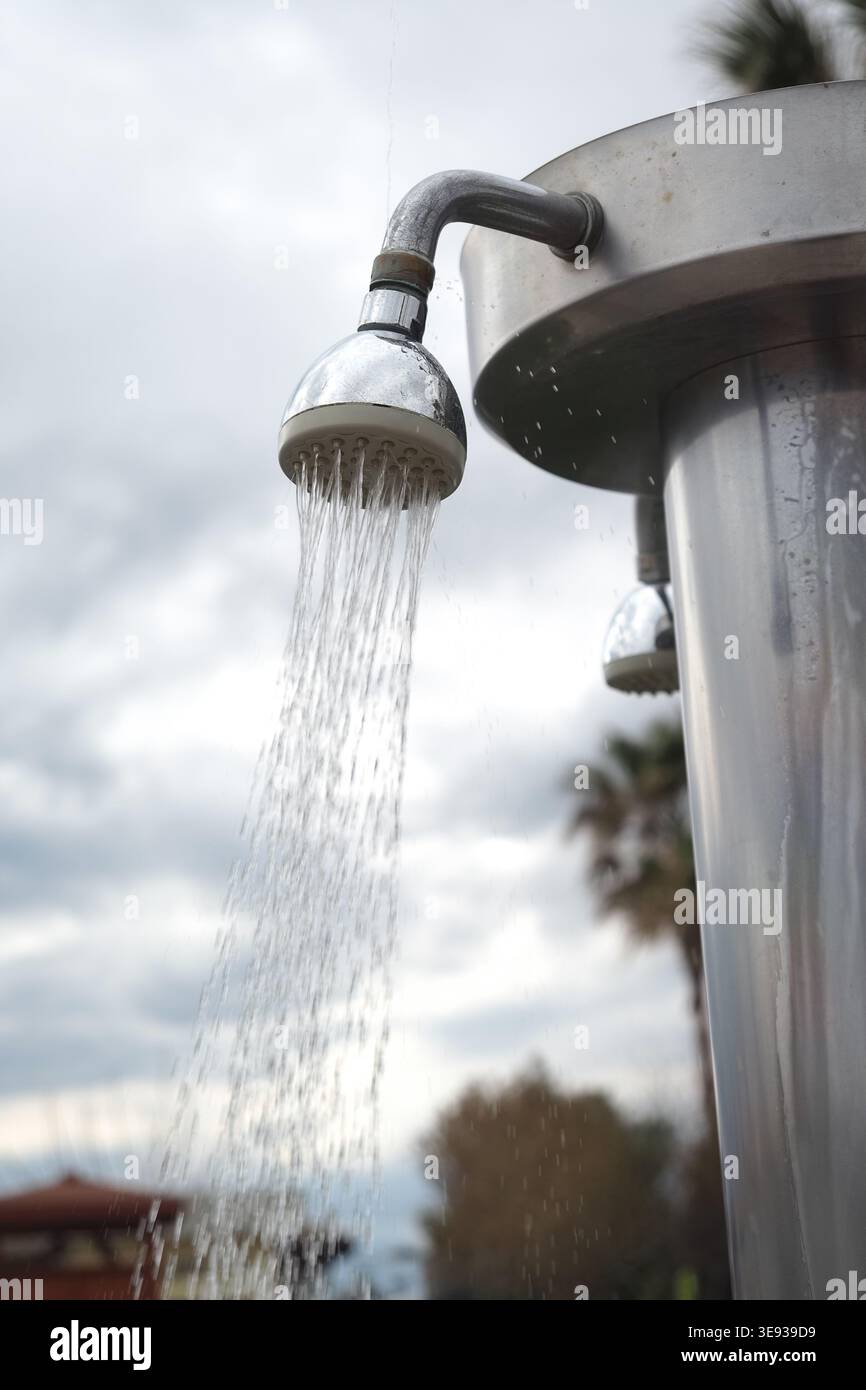 L'eau coule d'une pomme de douche dans un cadre extérieur Banque D'Images