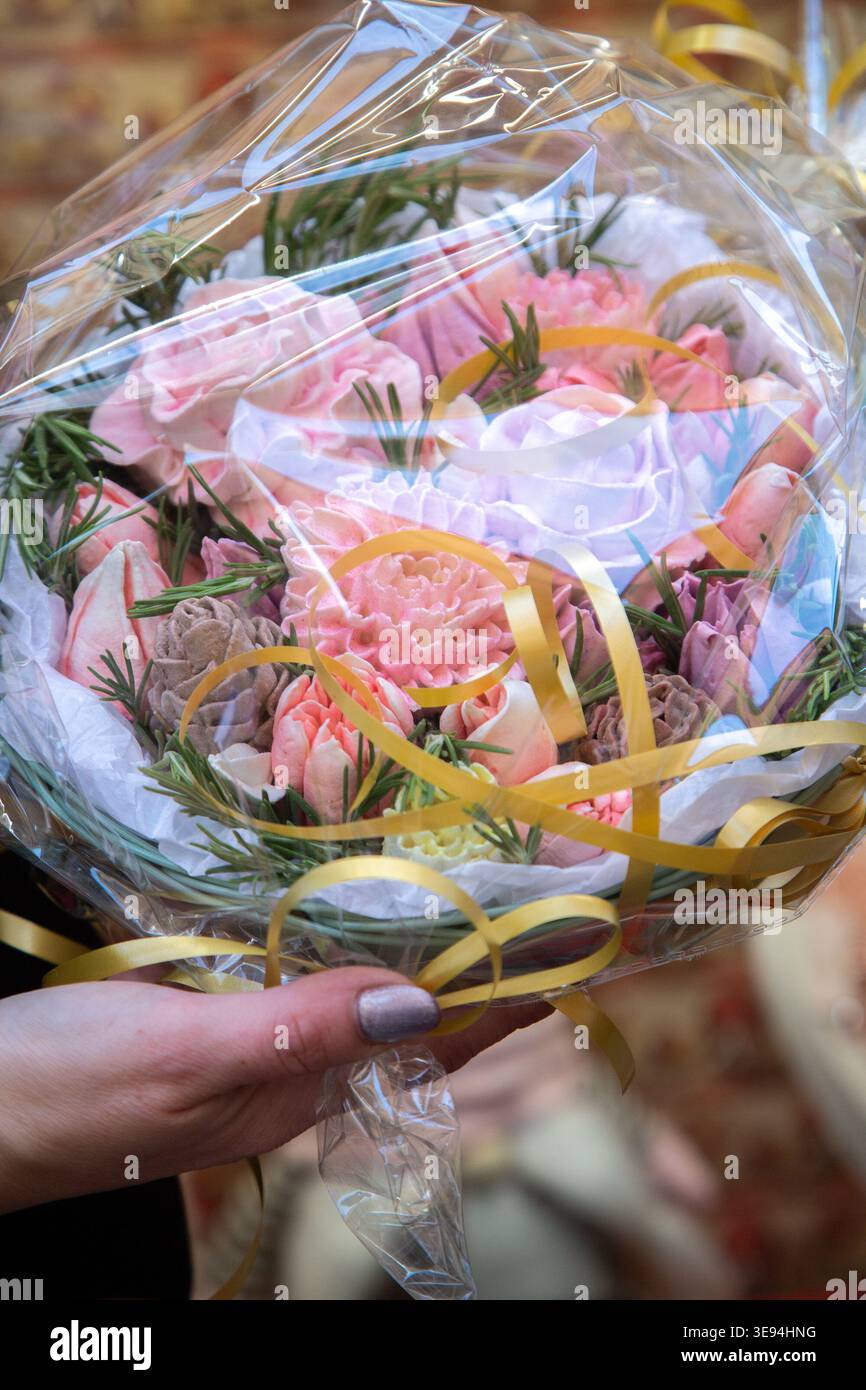 Enthousiaste Flower Expert présente un charmant assortiment de roses et œillets de couleur pastel Banque D'Images