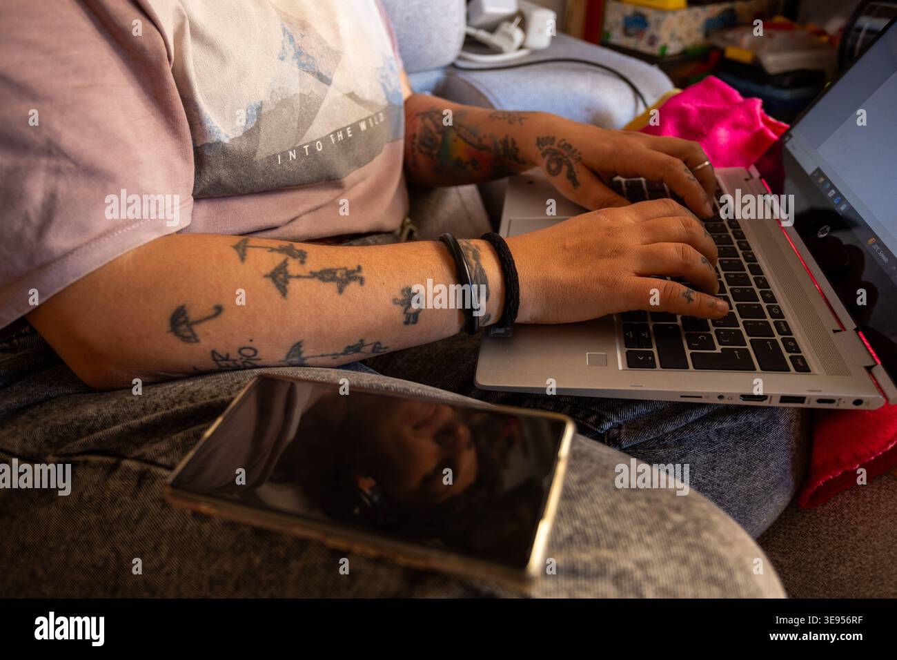 Gros plan des mains tatouées tapant sur le clavier d'ordinateur portable pour indépendant créatif et concept alternatif de travail à distance Banque D'Images