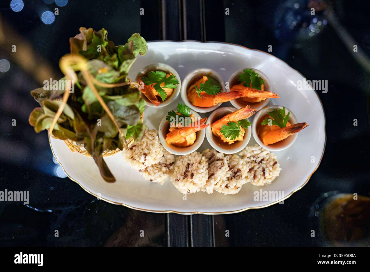 Plat de fruits de mer élégant apéritif avec fusion thaïlandaise de gâteau de riz croustillant, trempette épicée aux crevettes, légumes dans un restaurant de luxe Banque D'Images