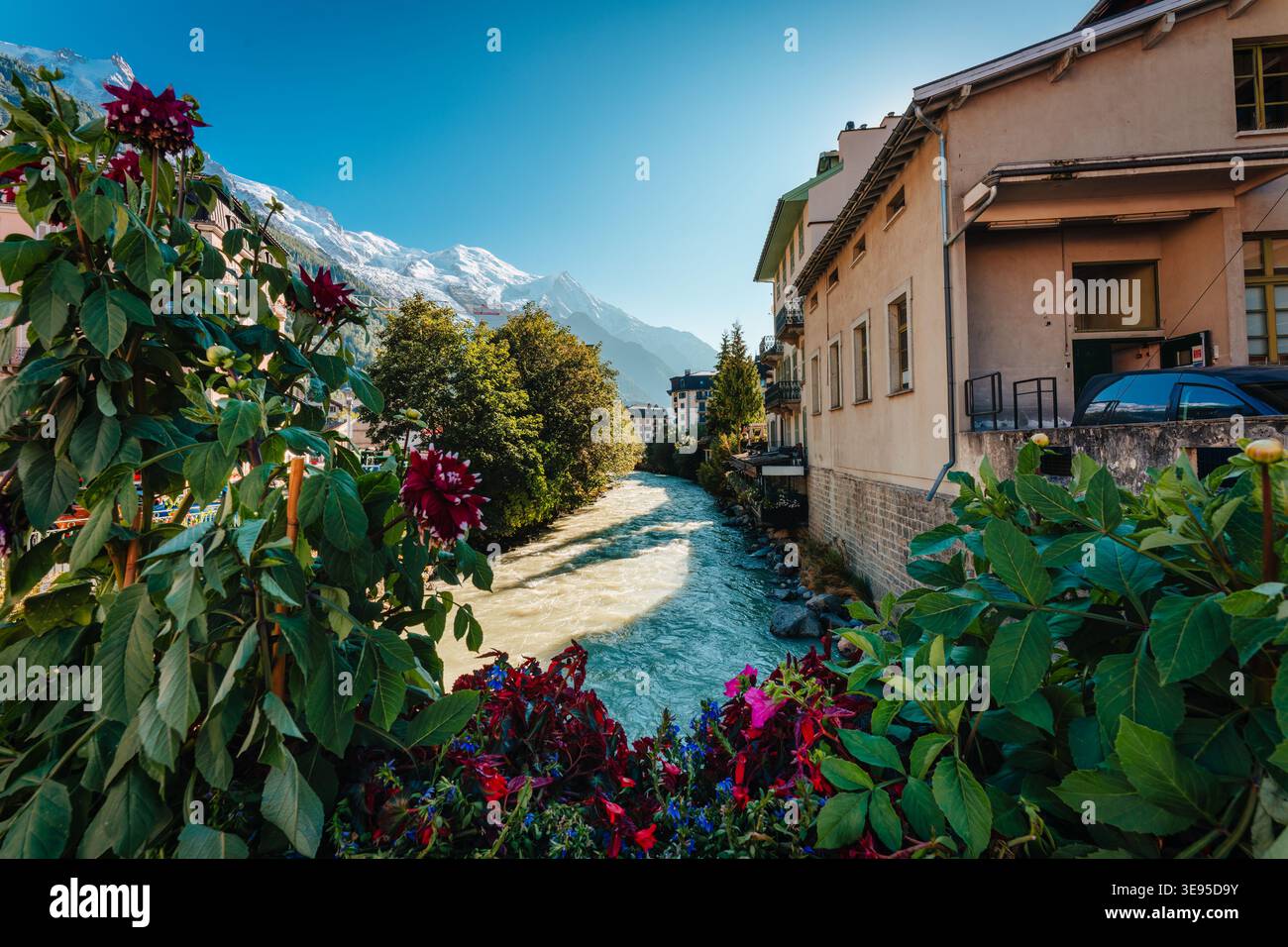 Vue panoramique sur la rivière Arve coulant à travers le village de Chamonix Mont Blanc avec massif enneigé dans les Alpes françaises, France Banque D'Images