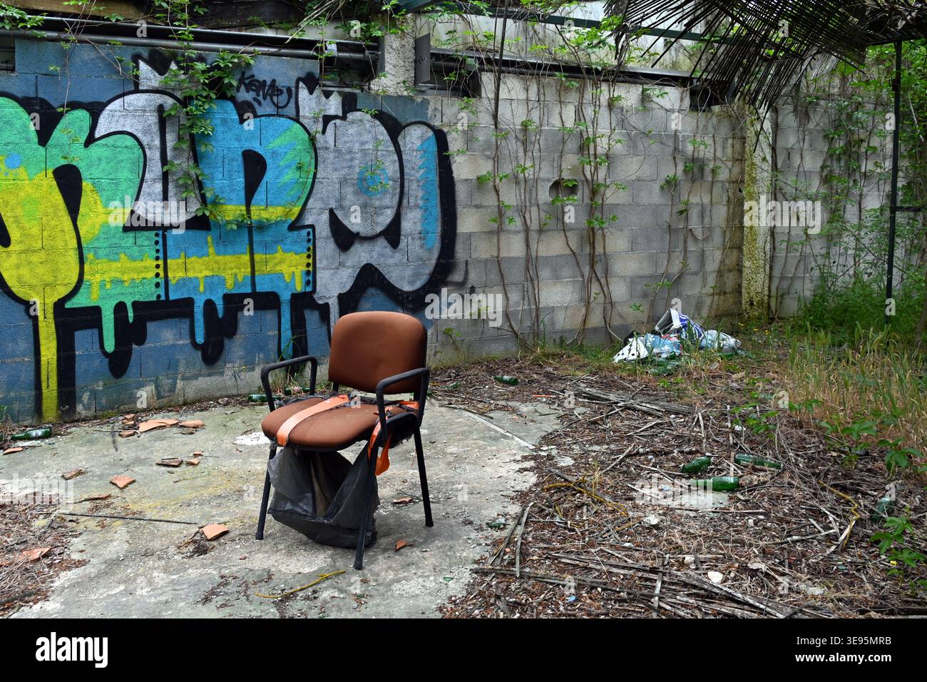 Chaise abandonnée ou fauteuil et mur couvert de gaffiti Banque D'Images