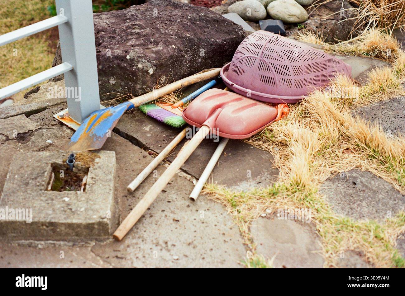 Outils de jardin et articles ménagers en plastique reposant sur le sol à l'extérieur Banque D'Images