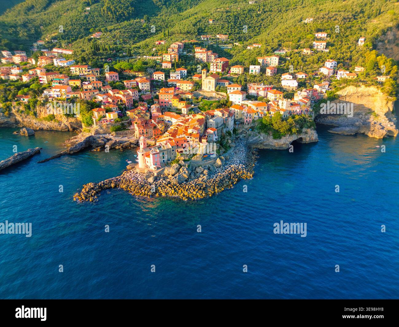Vue aérienne du village côtier coloré de Tellaro perché sur une falaise rocheuse surplombant la mer Méditerranée bleue avec des collines verdoyantes dans la BA Banque D'Images