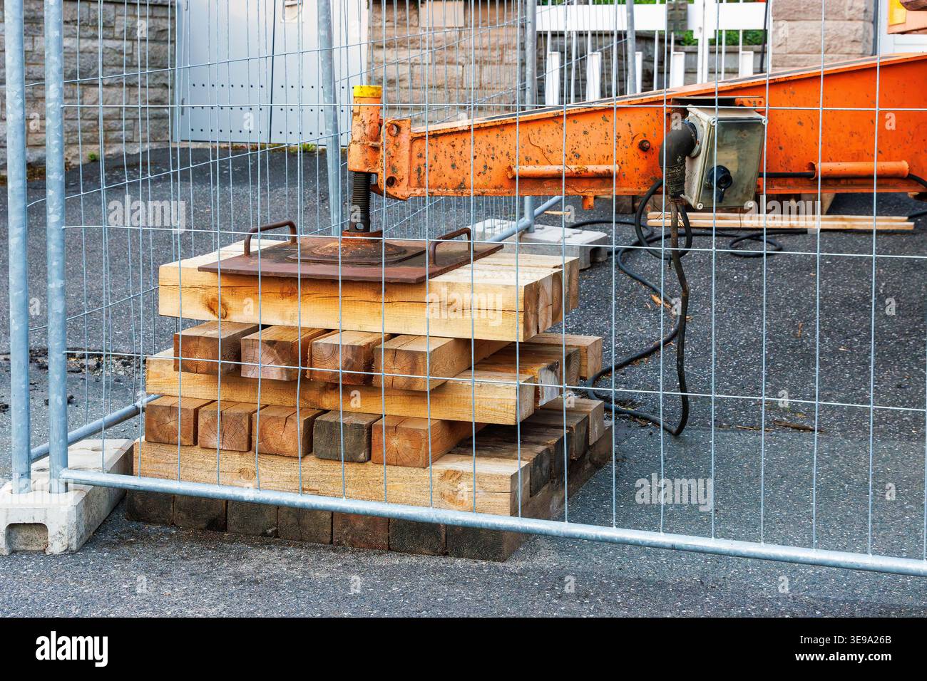 Support de grue en bois empilé derrière une clôture de sécurité. Configuration du support et de la stabilité de l'équipement lourd. Banque D'Images
