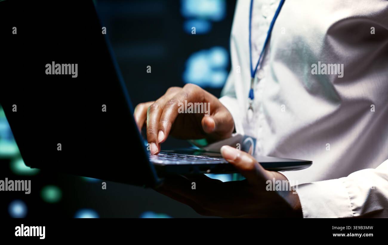Gros plan extrême d'un programmeur INFORMATIQUE expérimenté utilisant un ordinateur portable pour vérifier la sécurité des installations de haute technologie afin de protéger l'accès aux informations, en s'assurant que le logiciel de protection antivirus est mis à jour Banque D'Images