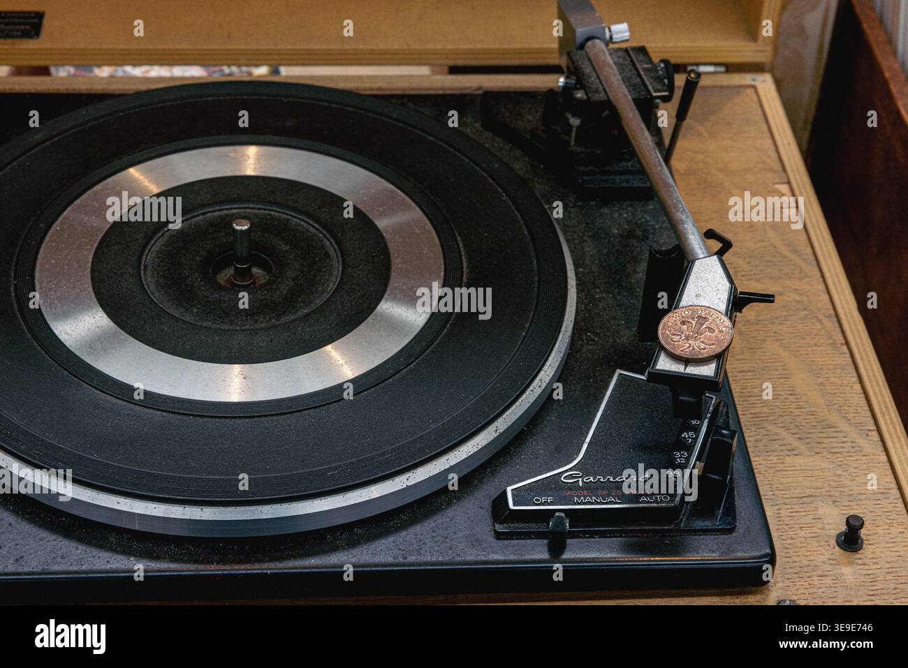 Platine vinyle vintage Garrard SP25 MK III des années 1970, avec une pièce britannique de deux pences placée sur la coque pour augmenter le suivi Banque D'Images