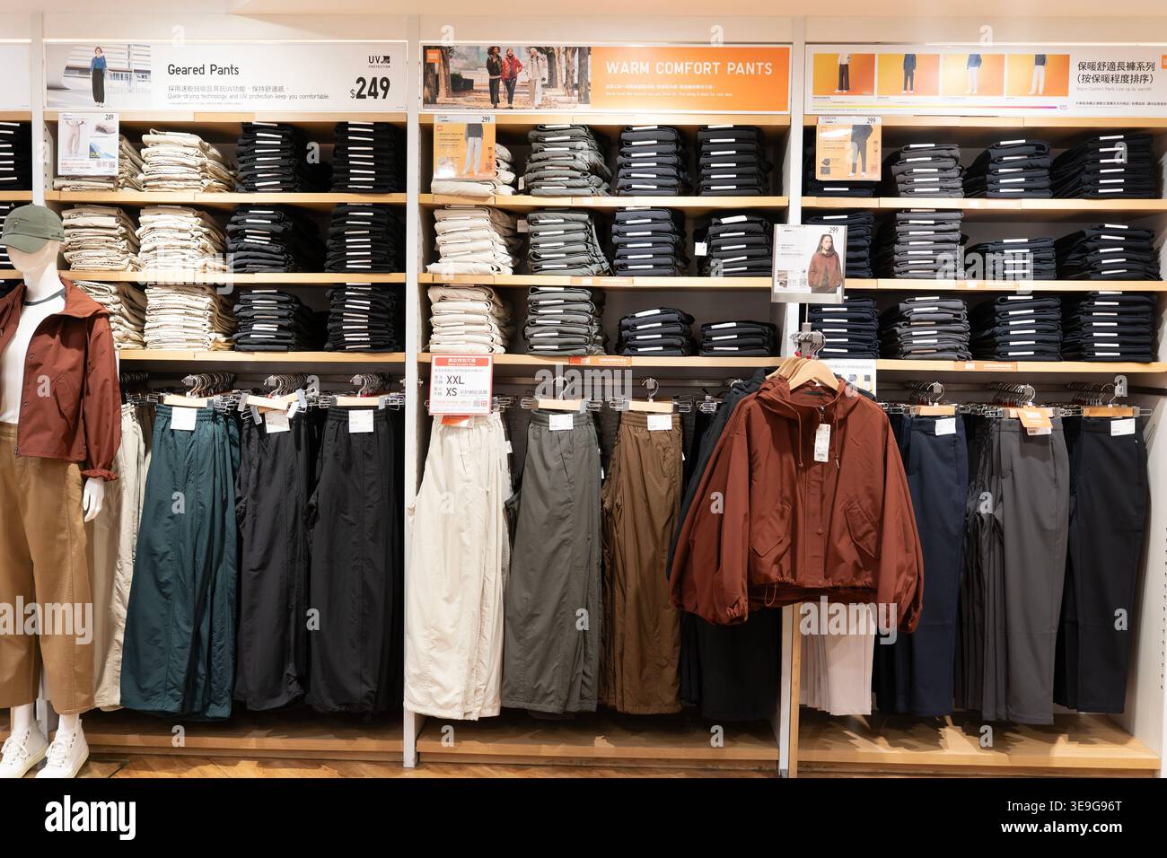 Hong Kong, Chine - 23 septembre 2025 : des piles de pantalons d'extérieur et de vêtements techniques sur les étagères d'Uniqlo. Banque D'Images