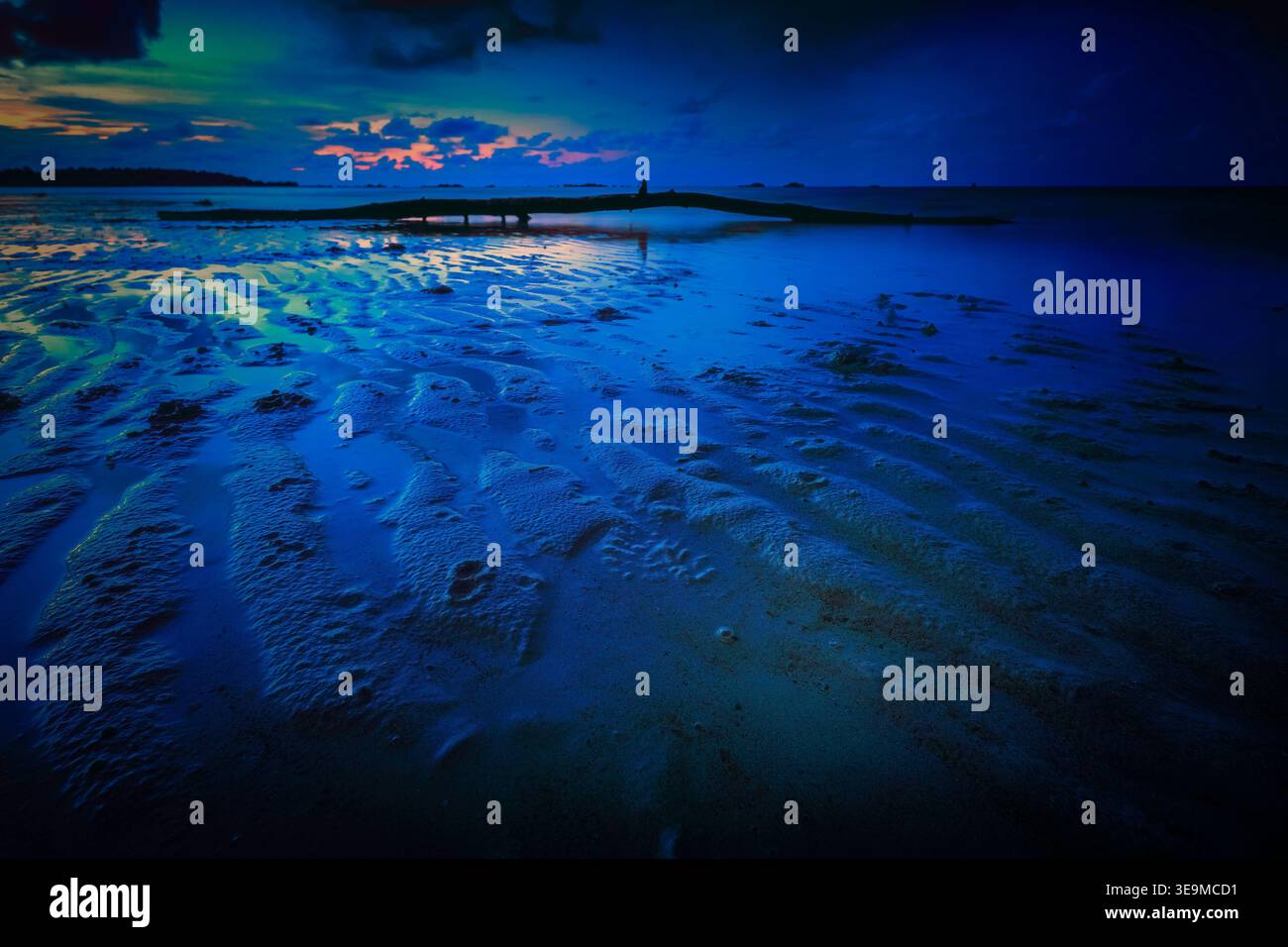 Vue sur le coucher de soleil sur la plage à marée basse Banque D'Images