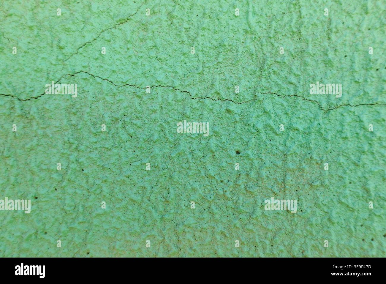 Mur vert avec surface texturée rugueuse et fissures sur fond Banque D'Images
