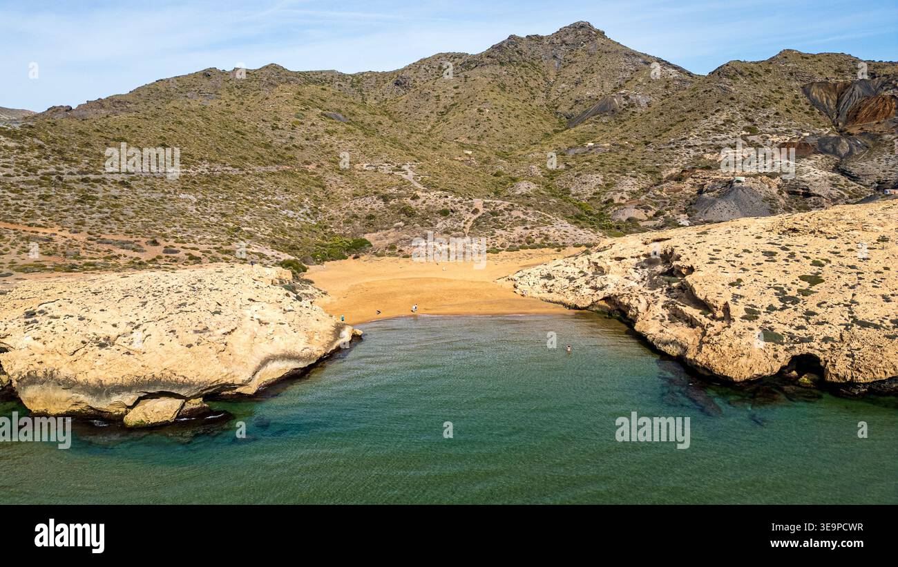 Superbe vue panoramique sur Cala Dorada à Murcie. Des eaux cristallines baignent la plage dorée entourée de falaises escarpées et de dunes fossiles. L'aride co Banque D'Images