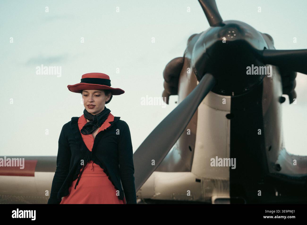 Une femme dans les années 1940 robe de guerre se tient seule devant le Spitfire MkVc EE602 à Sywell Aerodrome, Northamptonshire. Banque D'Images