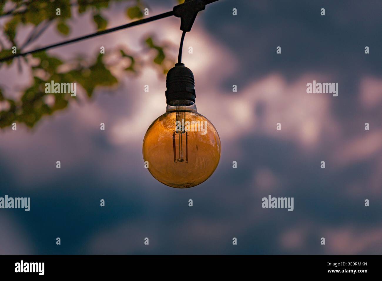 Suspension d'ampoule contre Moody Evening Sky en extérieur Banque D'Images