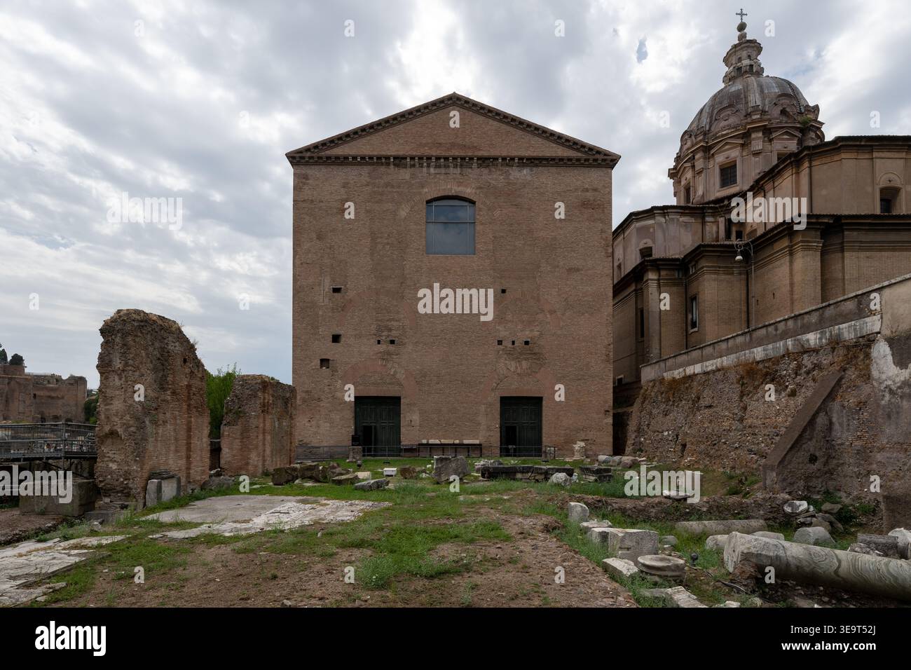 Extérieur de la Curie Julia, la maison du Sénat romain dans le Forum romain, avec façade en briques, fenêtres cintrées, et les ruines environnantes anciennes sous nuages Banque D'Images