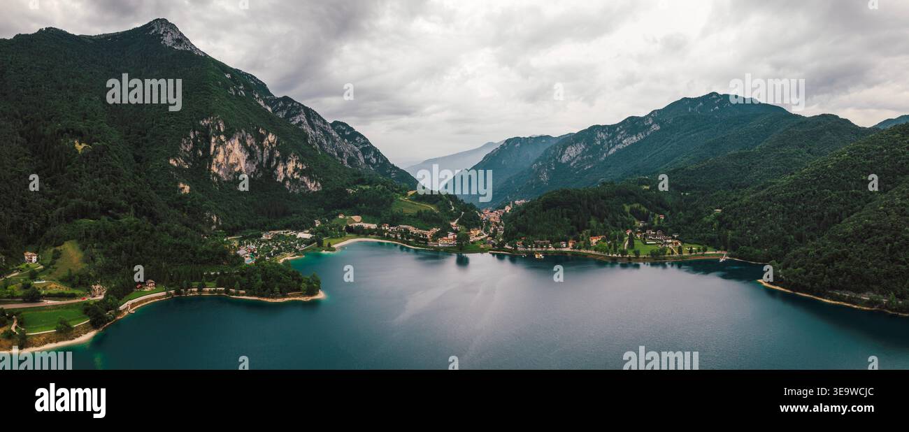Vue aérienne de Lago di Ledro en Italie avec eau turquoise, montagnes verdoyantes et village Molina di Ledro sous ciel nuageux Banque D'Images