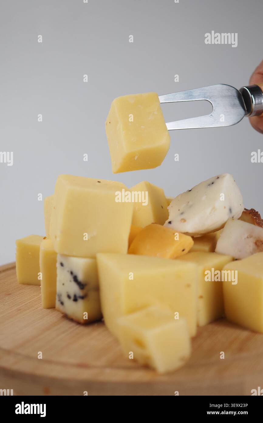 Déguster du fromage sur une planche de bois dans un cadre de cuisine Banque D'Images