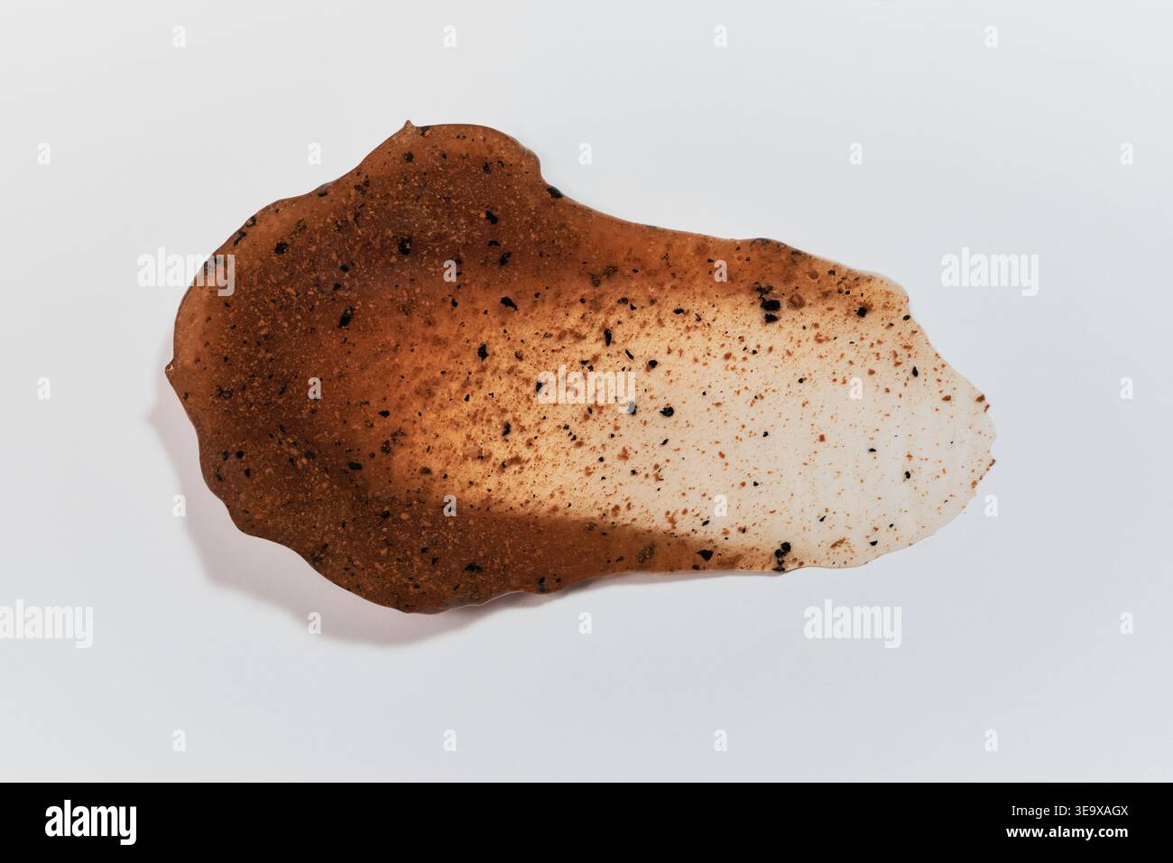 Échantillon de produit cosmétique exfoliant brun avec des granules sur fond blanc Banque D'Images