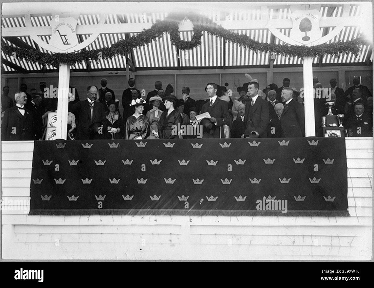 Les couronnes suédoises Gustaf Adolf (1882-1973) inaugurent les Jubileums-Landtbruksmöte à Nyköping en 1914. Le tirage photographique historique reproduit la cérémonie d'ouverture royale, y compris les spectateurs et les structures d'exposition. L'image d'archives préserve l'événement et la présence royale. Banque D'Images