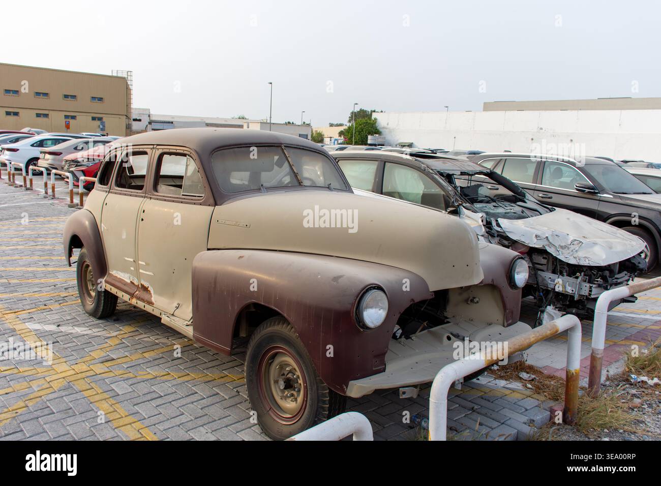 Une vieille voiture de collection vintage dans un terrain de fourrière ou une déchirure attend la restauration. Banque D'Images