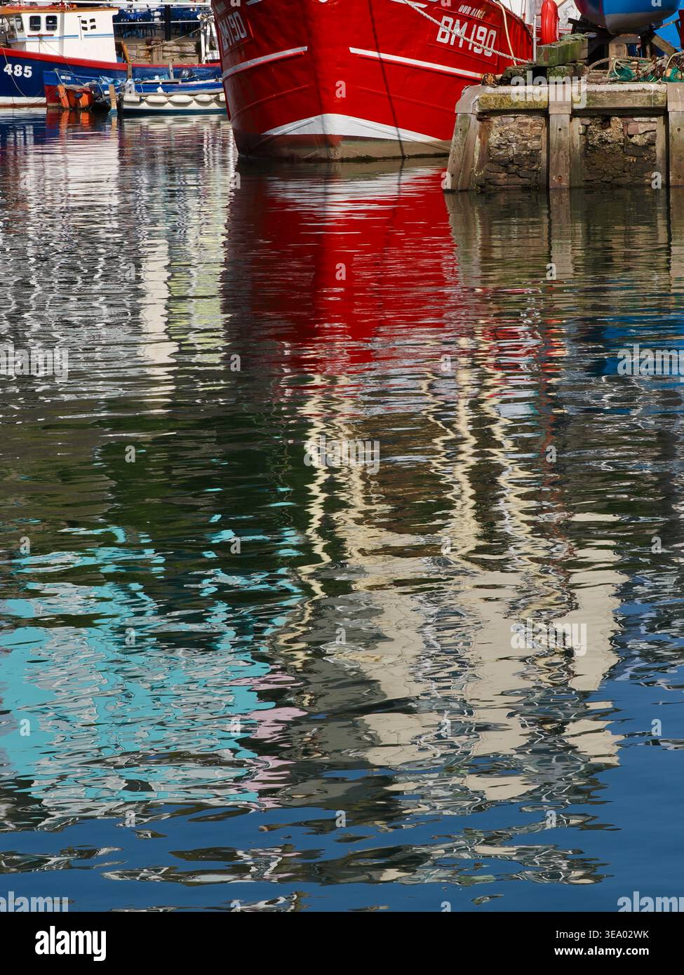 Chalutier rouge vif amarré dans le port de la pittoresque ville balnéaire de Brixham, Devon, Royaume-Uni Banque D'Images