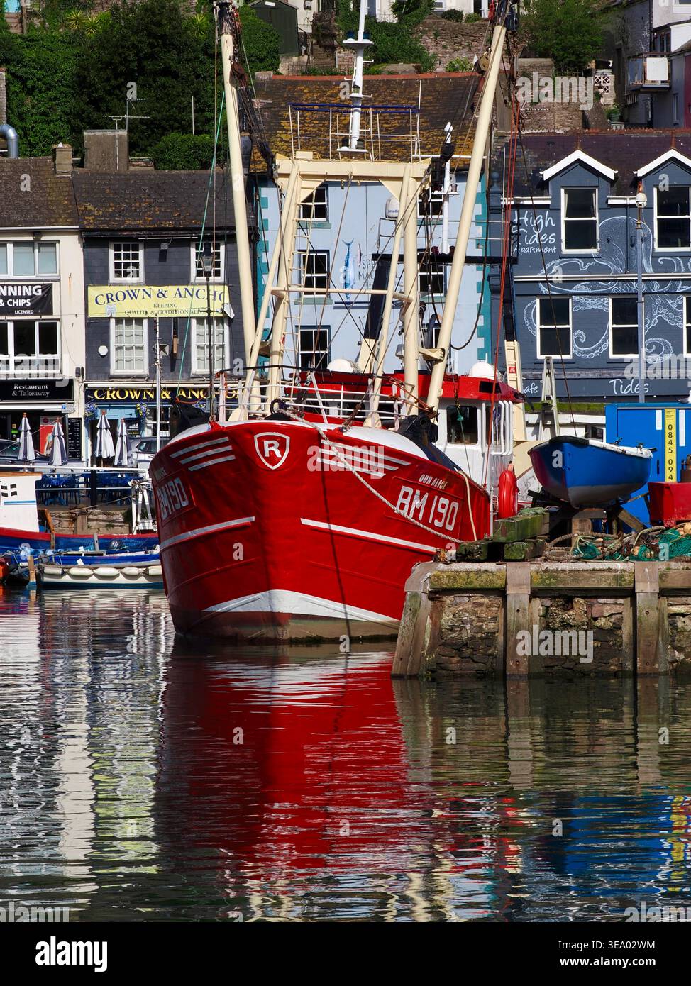 Chalutier rouge vif amarré dans le port de la pittoresque ville balnéaire de Brixham, Devon, Royaume-Uni Banque D'Images