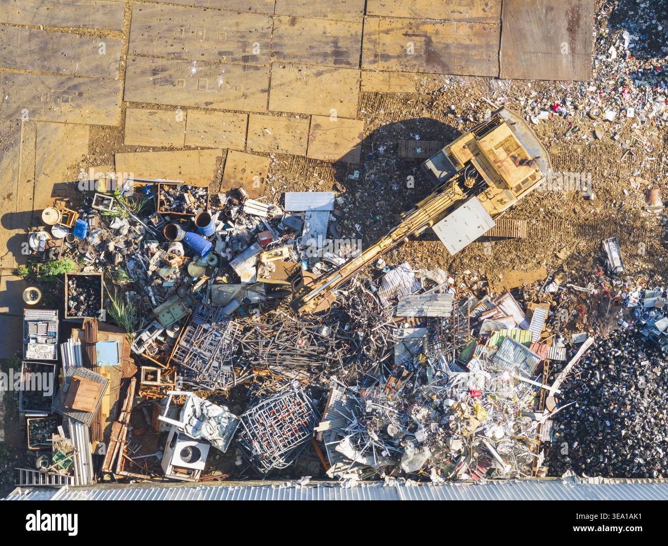 Vue aérienne d'une usine de récupération des ressources avec une excavatrice déplaçant des piles de ferraille et de déchets industriels à Taiwan. Banque D'Images