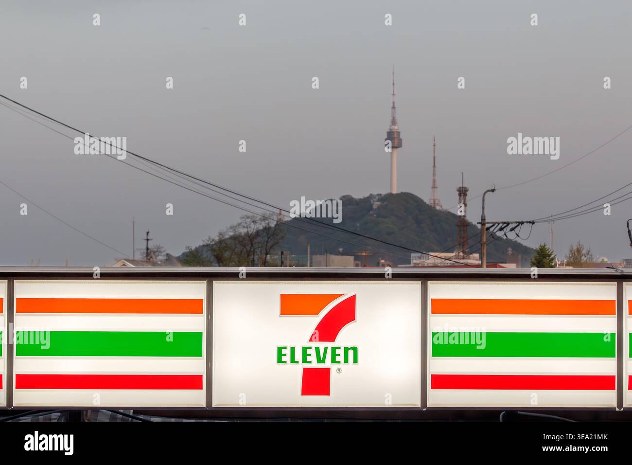 Magasin Seven Eleven à Séoul, Corée du Sud. Panneau lumineux rapproché du magasin avec N Seoul Tower et Namsan Mountain en arrière-plan. Banque D'Images