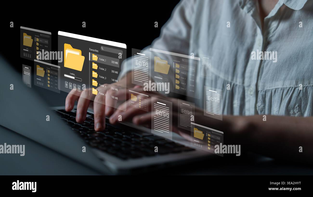 Un professionnel capture l'essence d'un espace de travail numérique, mettant en valeur l'organisation des fichiers aux côtés de mains concentrées sur un clavier d'ordinateur portable dans un moderne Banque D'Images
