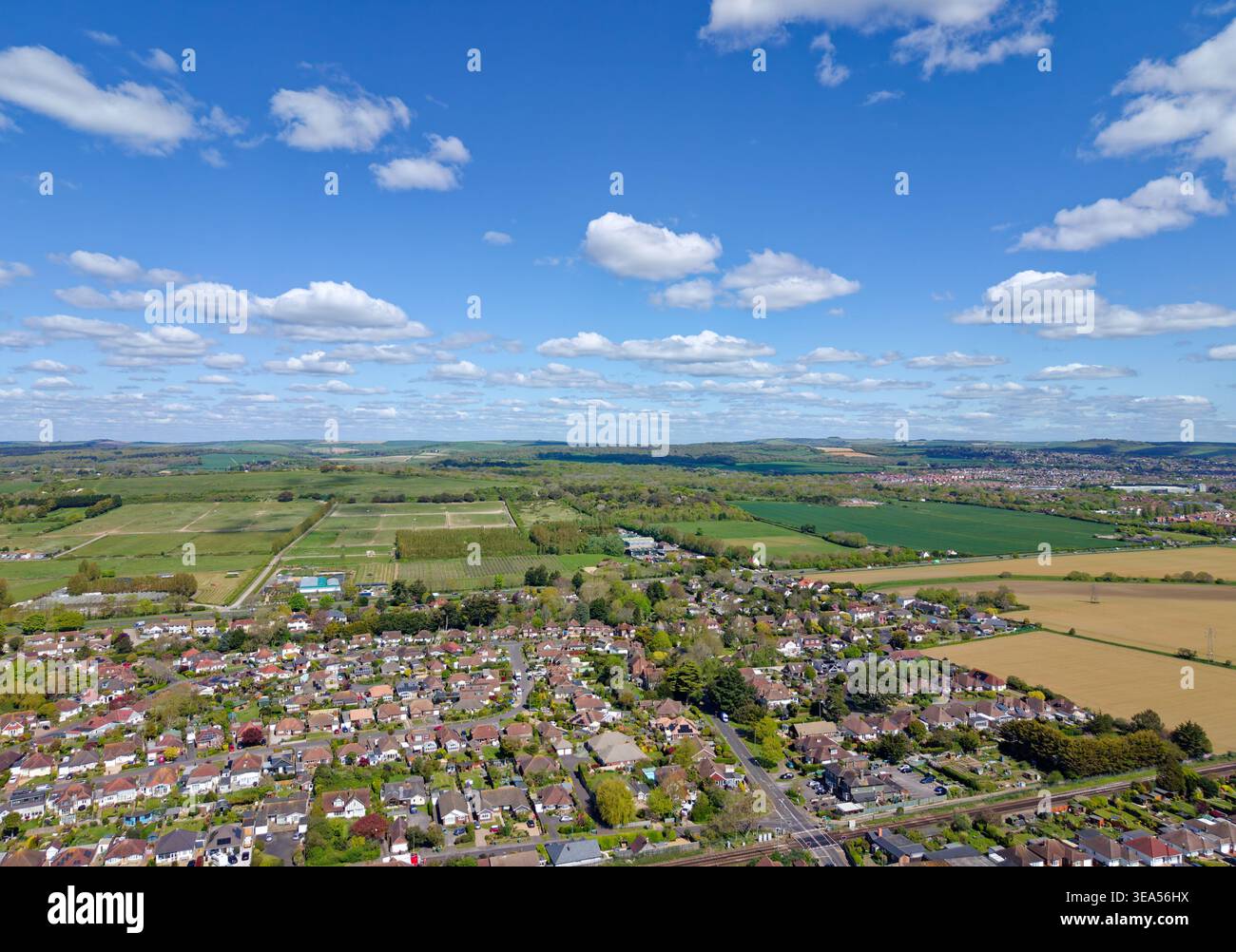 Vue aérienne sur le village de Ferring, dans le Sussex de l'Ouest, donnant sur les logements résidentiels vers les South Downs, lors d'une journée de printemps ensoleillée en Angleterre, au Royaume-Uni. Banque D'Images