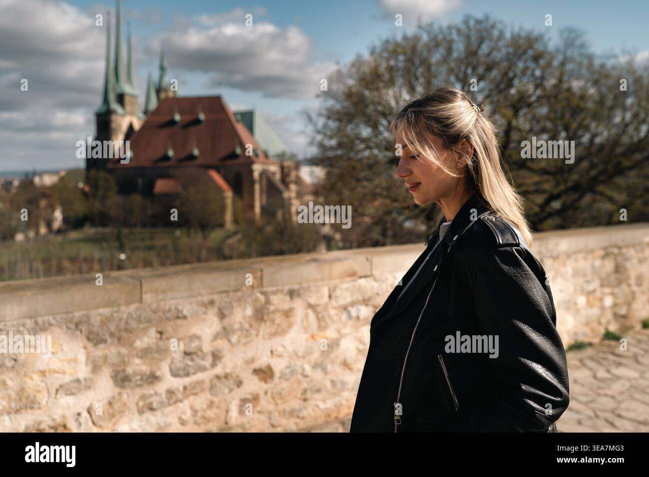 Vue latérale de la femme marchant près de l'église historique dans la ville européenne Banque D'Images