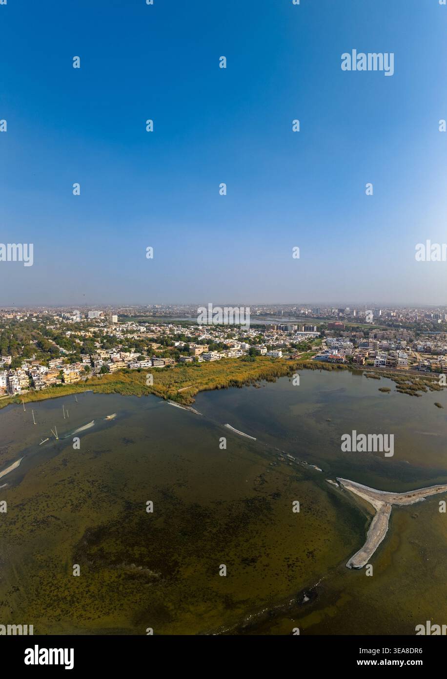 Vue aérienne du paysage urbain et des zones humides avec des bâtiments résidentiels denses sous un ciel bleu clair à Hyderabad, Sindh, Pakistan. Banque D'Images