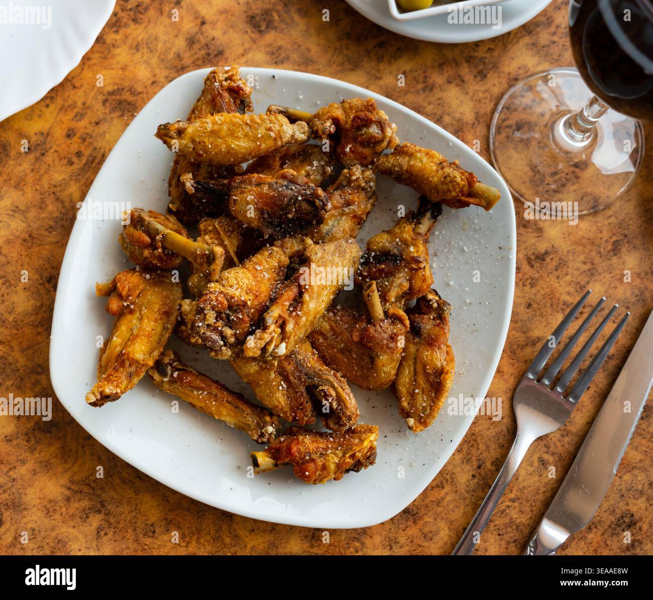 Il y a une collation copieuse sur l'assiette - une grande portion d'ailes de poulet frites Banque D'Images