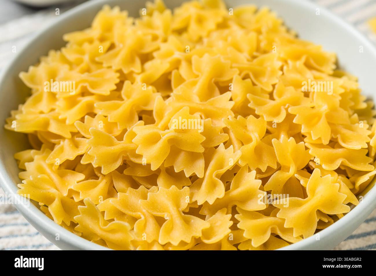 Pâtes biologiques à nouer au noeud au Mini Farfalle dans un bol Banque D'Images