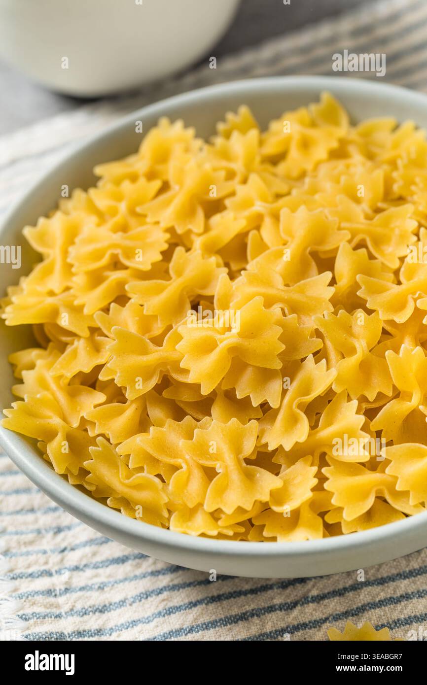 Pâtes biologiques à nouer au noeud au Mini Farfalle dans un bol Banque D'Images