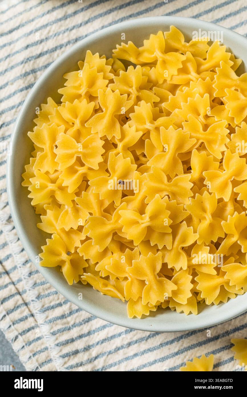 Pâtes biologiques à nouer au noeud au Mini Farfalle dans un bol Banque D'Images