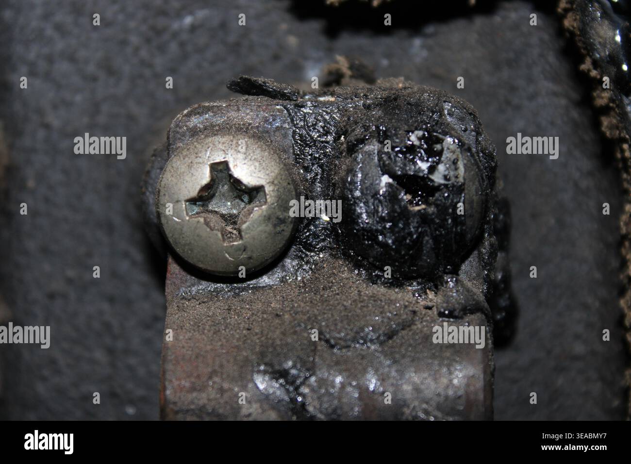 Comparaison d'un boulon propre et d'un boulon recouvert de suie d'une chaudière de chauffage Banque D'Images