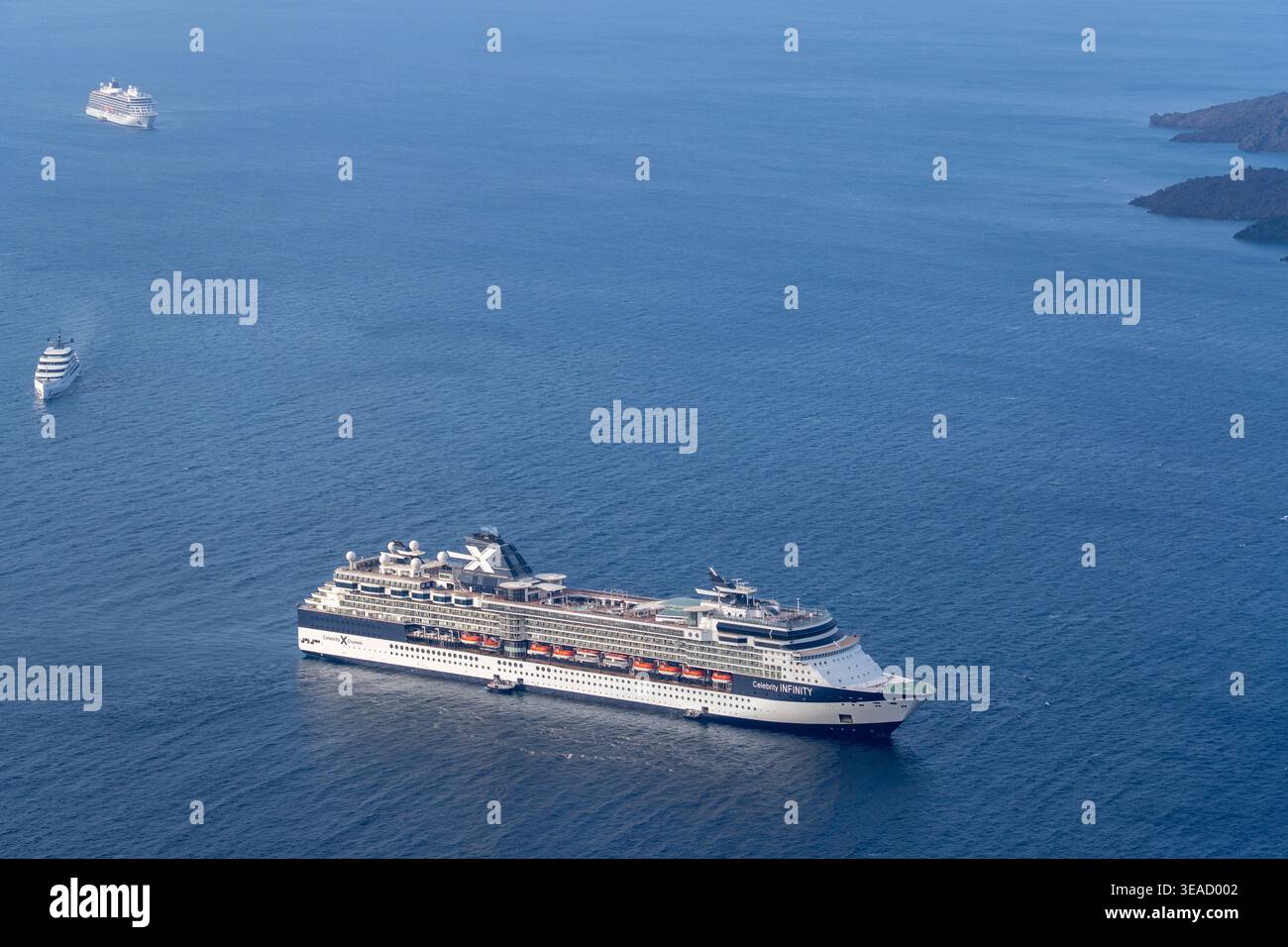 Une photo détaillée en grand angle du bateau de croisière Celebrity Infinity ancré dans les eaux bleues profondes de la mer Égée au large de Santorin. Banque D'Images