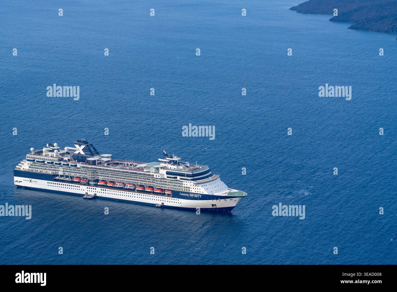 Une photo détaillée en grand angle du bateau de croisière Celebrity Infinity ancré dans les eaux bleues profondes de la mer Égée au large de Santorin. Banque D'Images