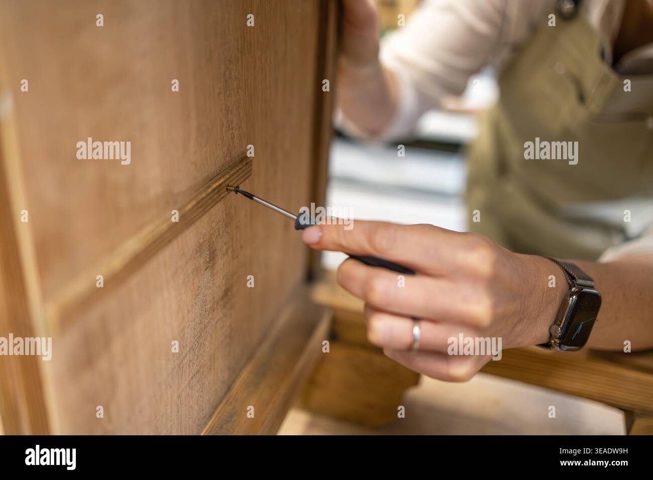 Vis de serrage dans les meubles en bois avec tournevis gros plan Banque D'Images