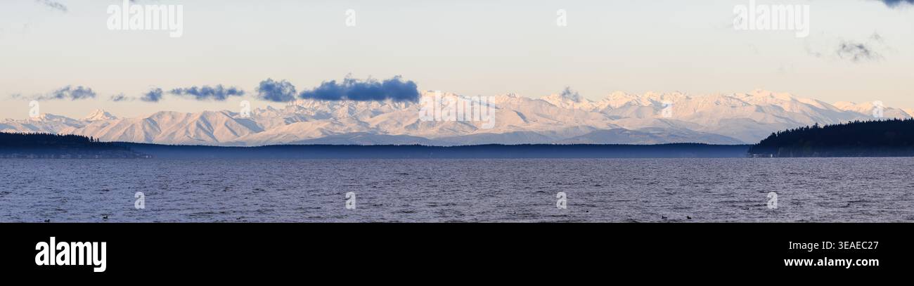Vue panoramique sur la baie de Skagit à l'aube jusqu'aux montagnes olympiques recouvertes de neige lointaines Banque D'Images