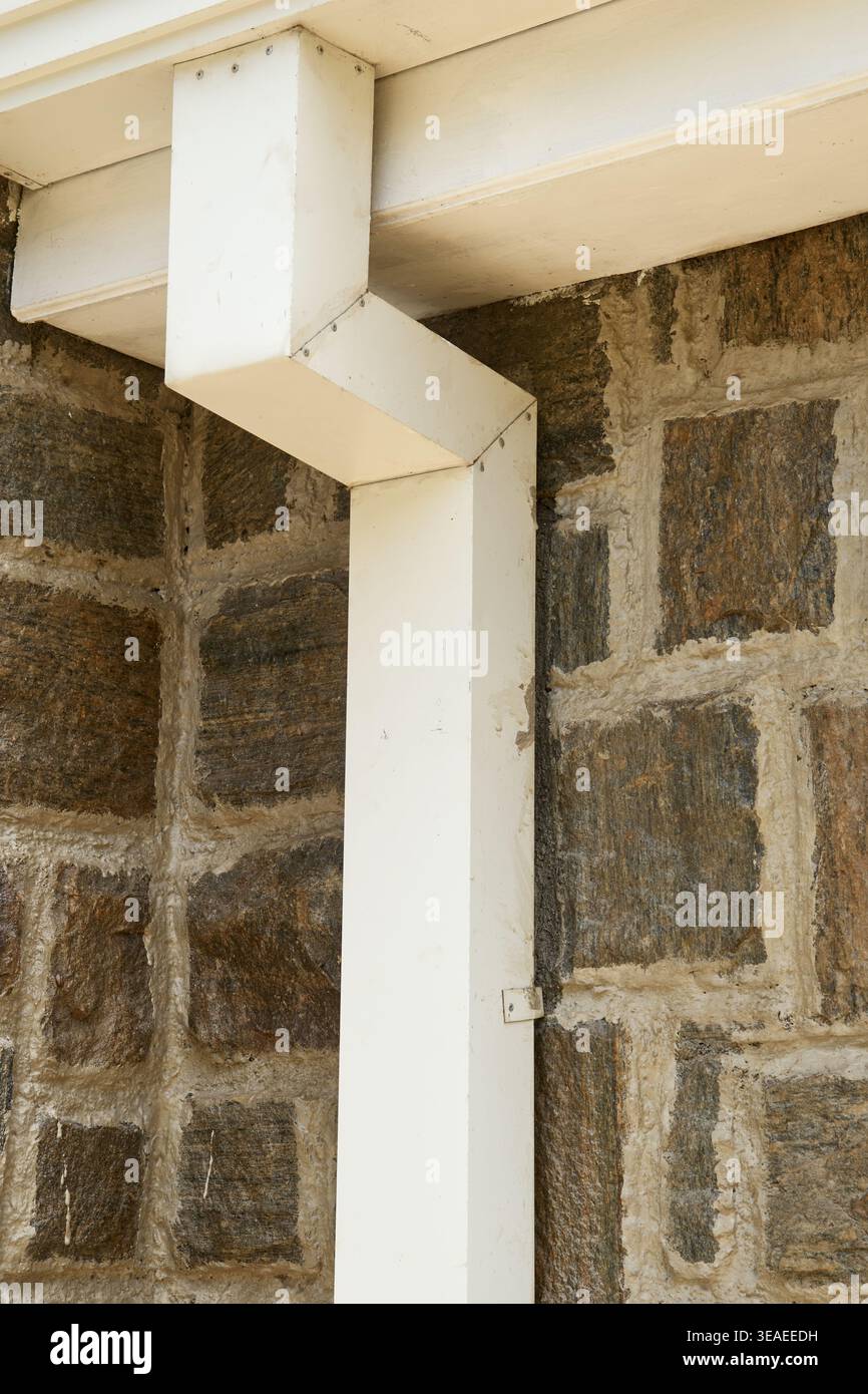 goulotte de descente de gouttière carrée blanche sur mur de pierre, système de drainage résidentiel sur surface brune texturée dans la mise au point douce, l'entretien de la maison ou la construction Banque D'Images