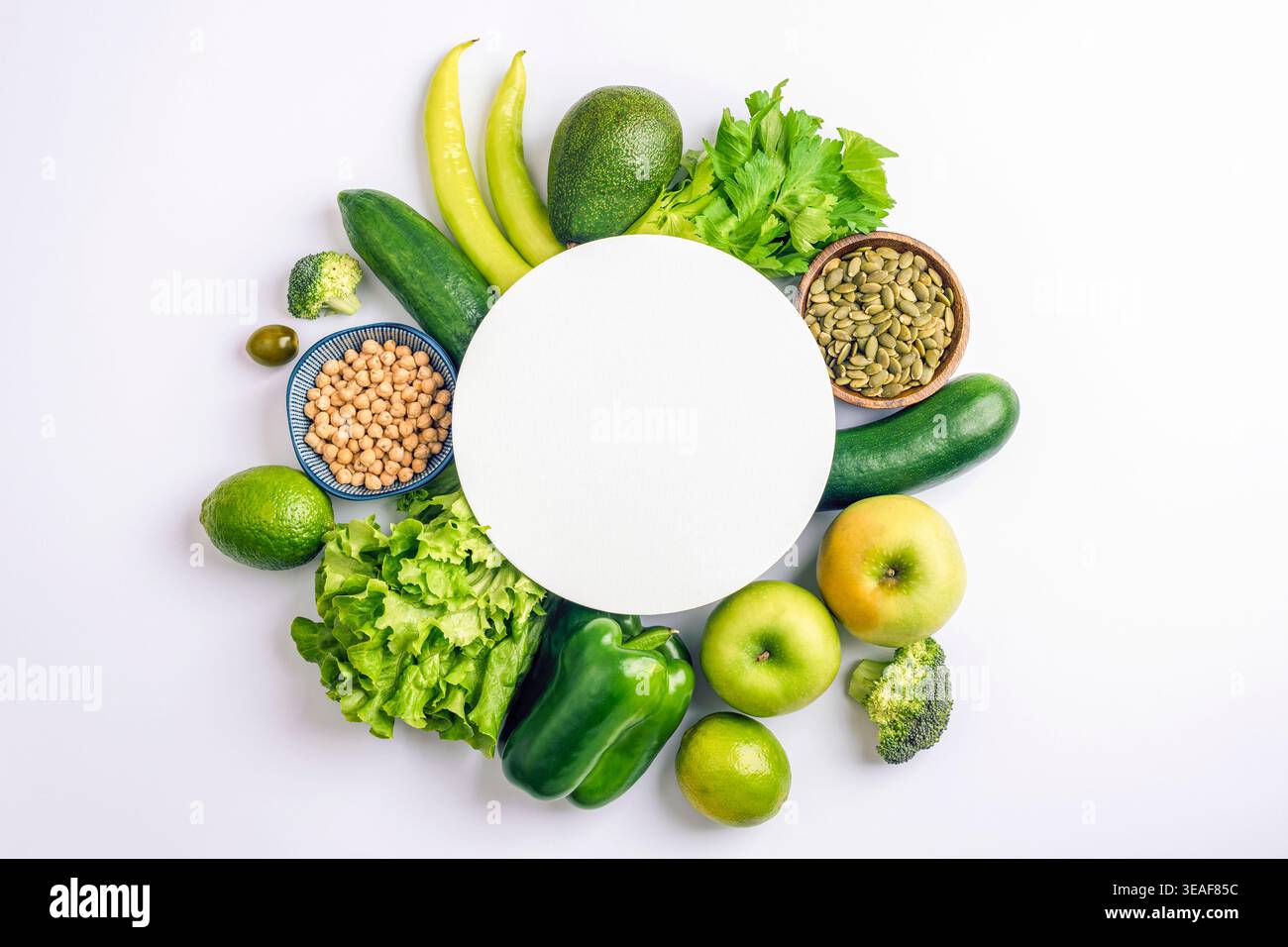 Composition alimentaire saine et fraîche disposée dans un cadre circulaire avec des légumes, des fruits et des grains autour d'un espace vide sur fond blanc transportant la balance Banque D'Images