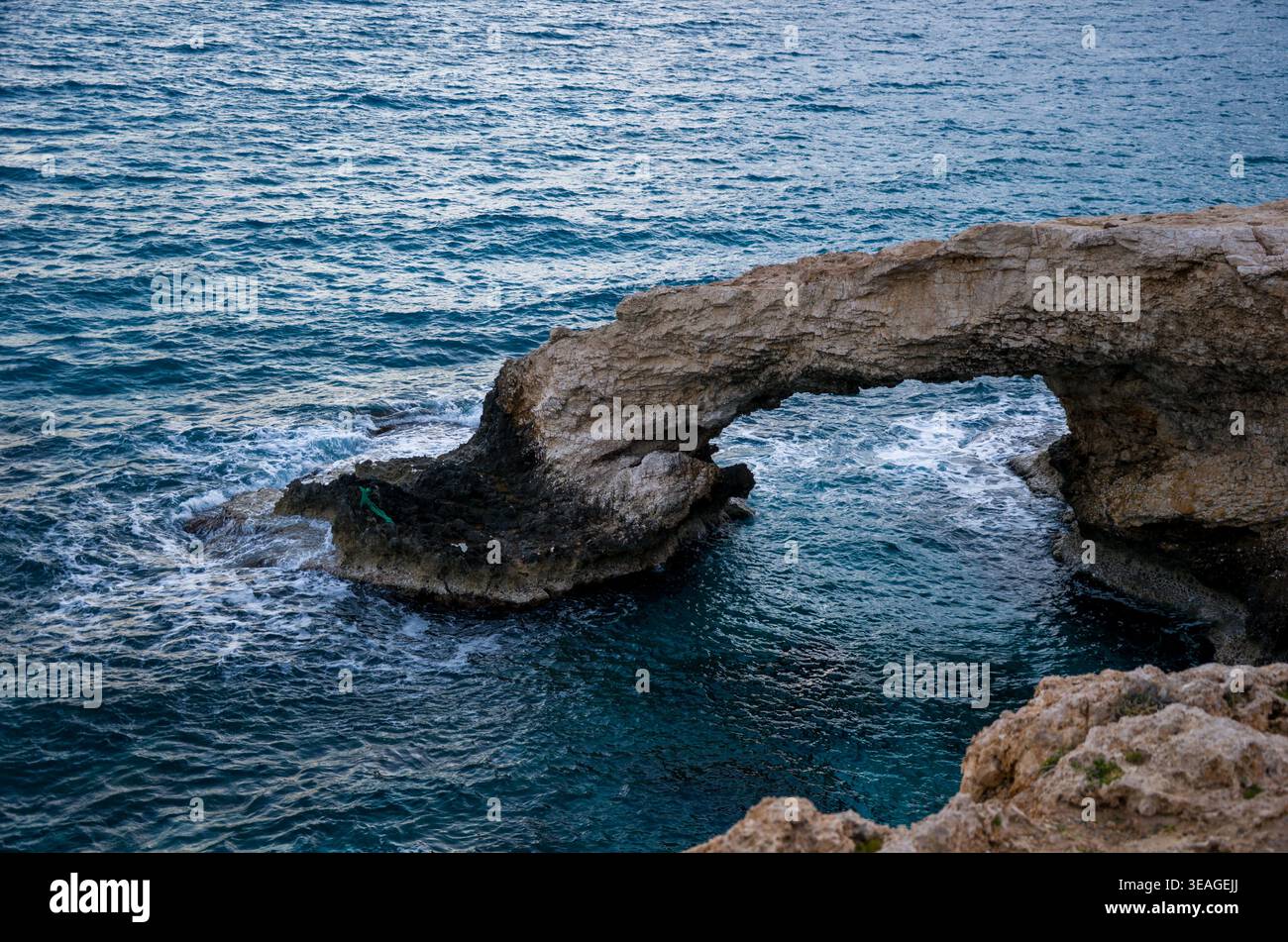 Arc en pierre naturelle au-dessus des eaux de l'océan bleu Banque D'Images
