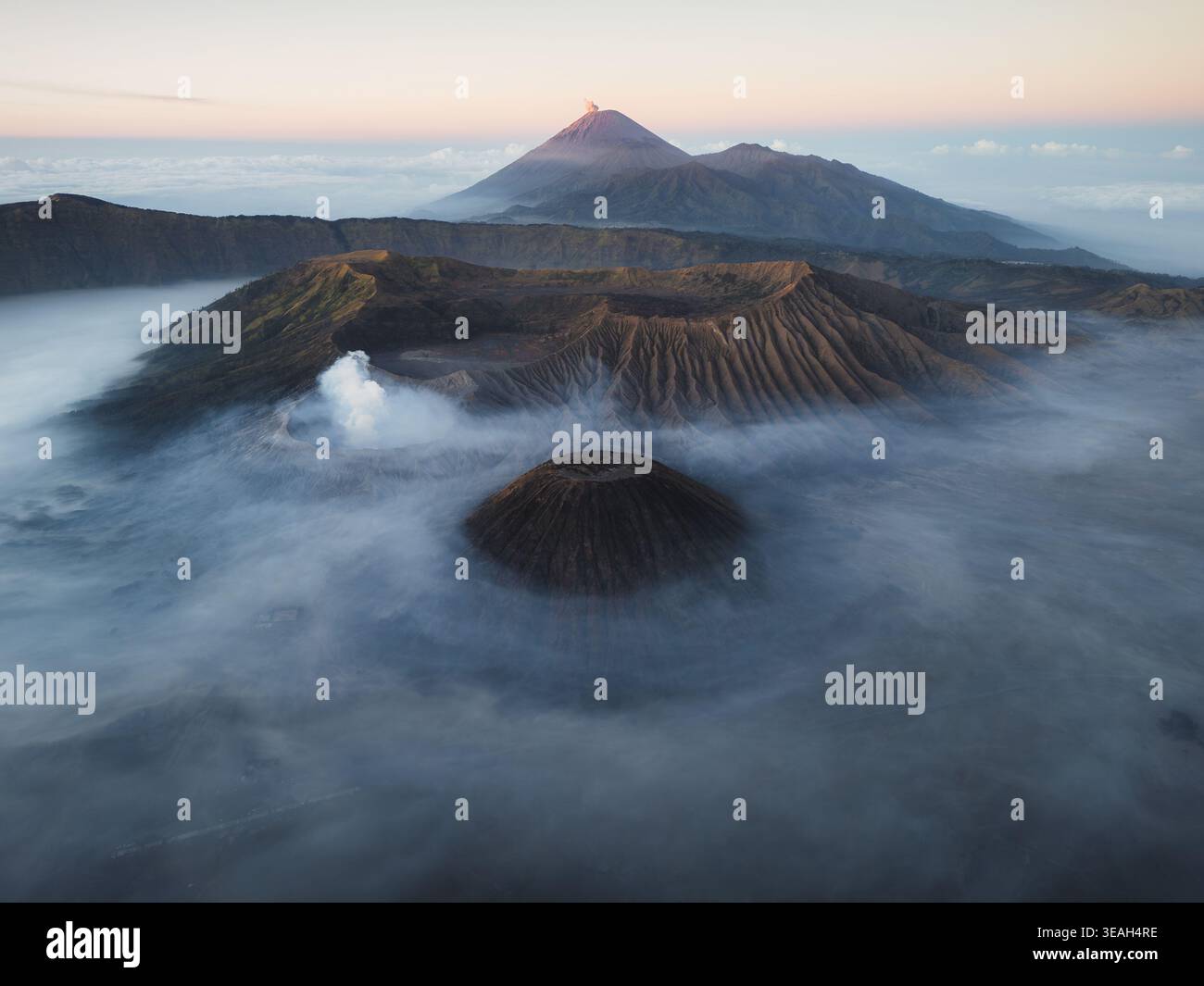 Vue aérienne du mont bromo et du mont Batok entourés de brume dans le parc national bromo Tengger Semeru, bromo, Java oriental, Indonésie. Banque D'Images