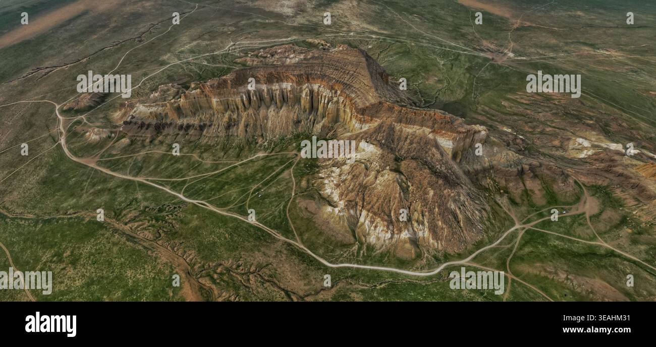 Vue aérienne des majestueuses formations rocheuses en couches et des falaises abruptes s'élevant du paysage vert de steppe à Mangistau, région de Mangystau, Kazakhstan Banque D'Images
