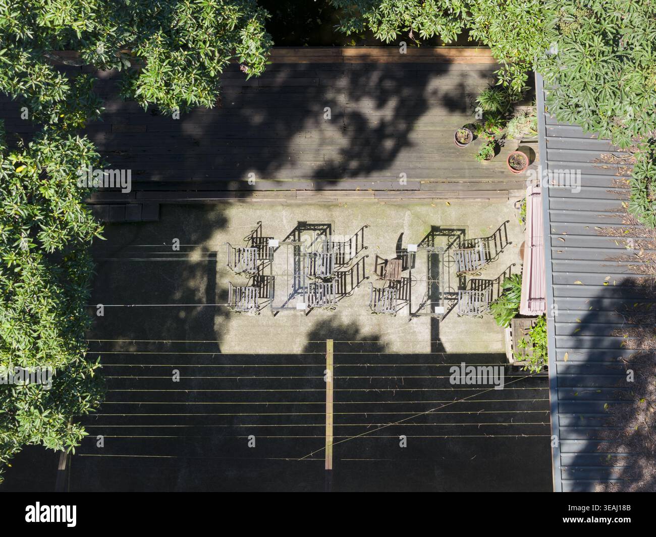 Vue aérienne des sièges de café en plein air et des tables sur un patio en béton entouré d'arbres verdoyants et d'une terrasse en bois à Taiwan. Banque D'Images