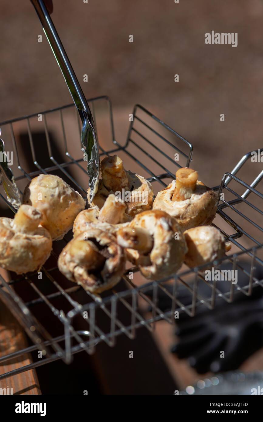 Gros plan détaillé de champignons blancs frais dans un panier de gril en métal. Texture alimentaire biologique naturelle pour la conception culinaire. Banque D'Images