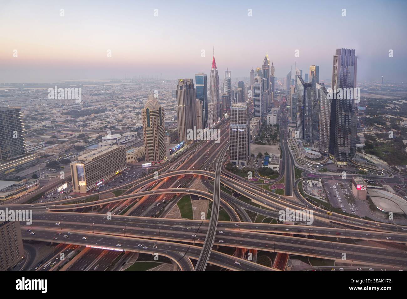 Vue aérienne des gratte-ciel modernes et des échangeurs routiers complexes le long de Sheikh Zayed Road au crépuscule à Dubaï, Dubaï, Émirats arabes Unis. Banque D'Images